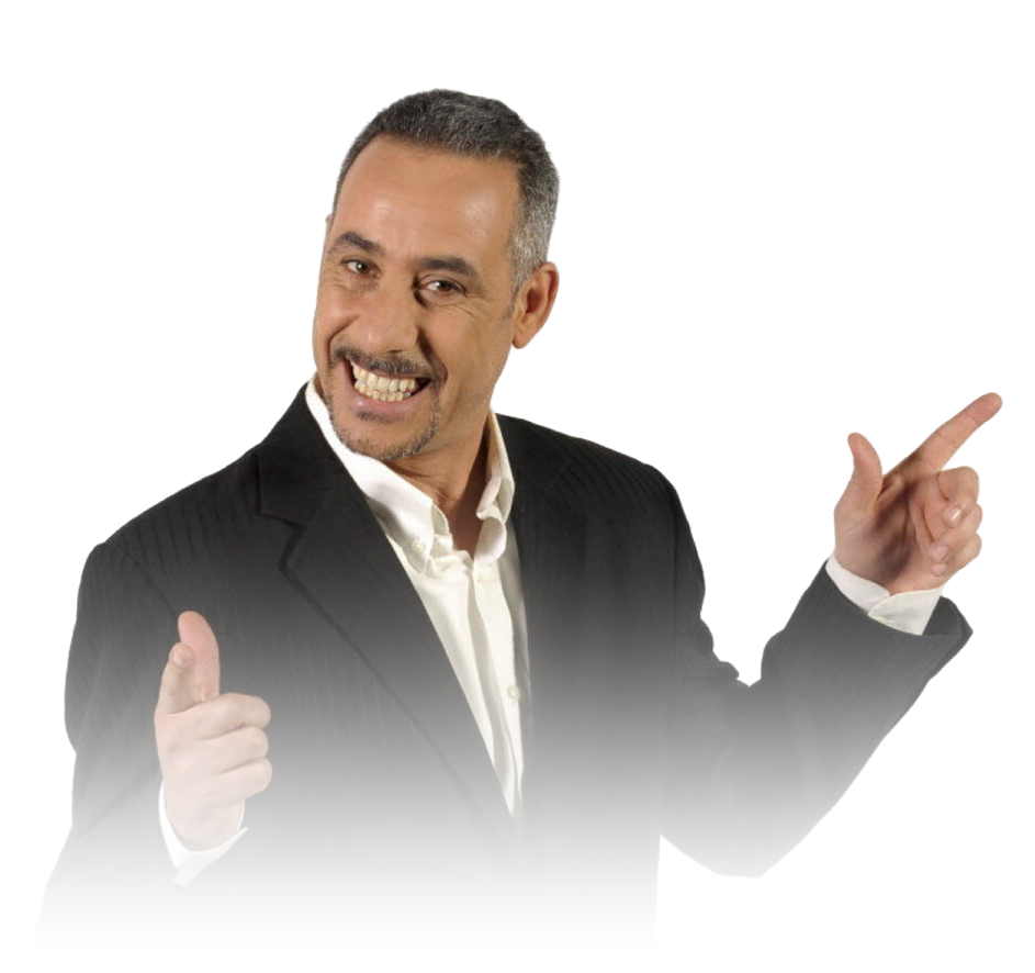 Abdelkader Secteur sourit et pointe du doigt, costume noir et chemise blanche